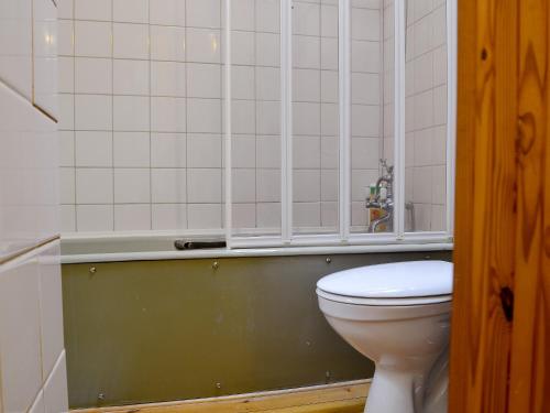 a bathroom with a toilet and a bath tub at Draigs Cottage in Abergavenny