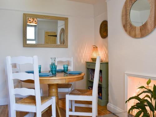 a dining room with a table and chairs and a mirror at Turnstone in Bideford