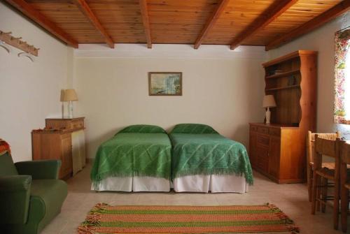 1 dormitorio con 1 cama con edredón verde en Gardeners Delight Studio La Casita Barrio Chapelco en San Martín de los Andes
