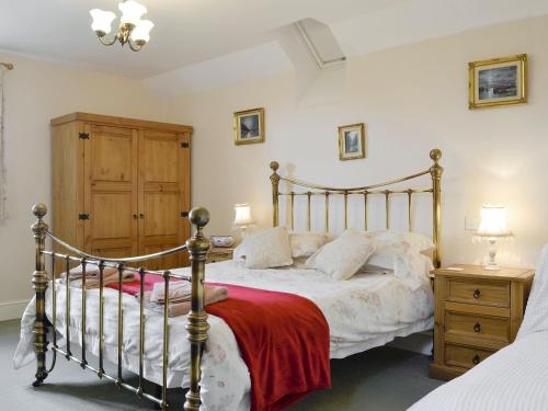 - une chambre avec un lit doté d'un cadre de lit en bois dans l'établissement White Hill Farm Cottage, à Dingestow
