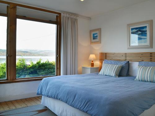 a bedroom with a bed and a large window at Tigh An Uillt in Strachur
