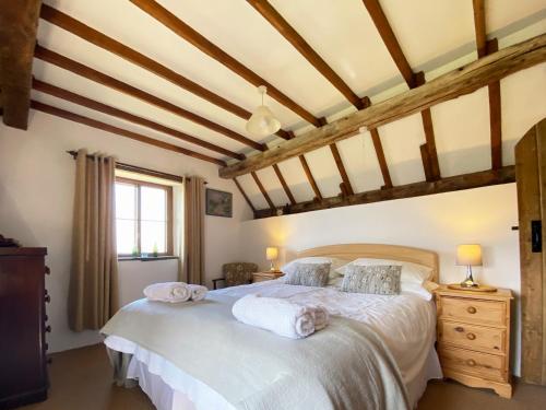 a bedroom with a large bed with towels on it at Titchbourne Cottage in Clee Saint Margaret