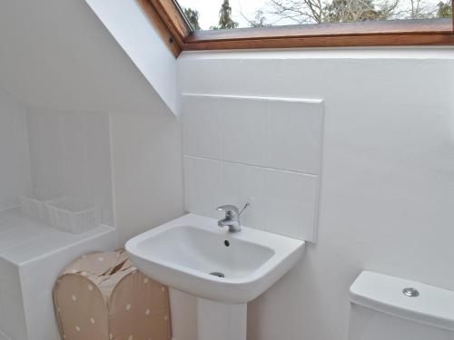 łazienka z umywalką, toaletą i oknem w obiekcie Heron Cottage w mieście Timsbury