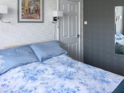 a bedroom with a bed with a blue blanket at The Briar Rose in New Herrington