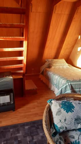 a attic room with two beds and a heater at Cabañas Linda Vista in Cucao