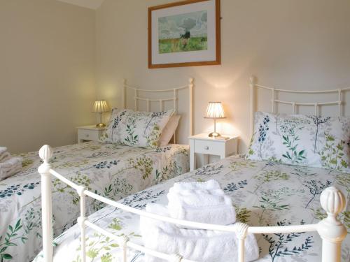 2 Betten in einem Schlafzimmer mit blauer und weißer Bettwäsche in der Unterkunft The Old Forge in West Lutton