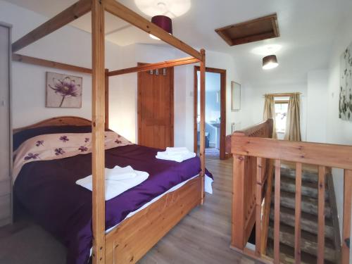 a bedroom with a wooden bunk bed and a staircase at The Calf Shed in Alston