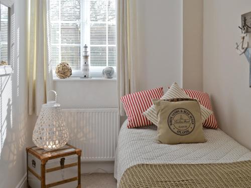 a bedroom with a bed with a pillow and a window at Willow Tree Cottage in Foxholes