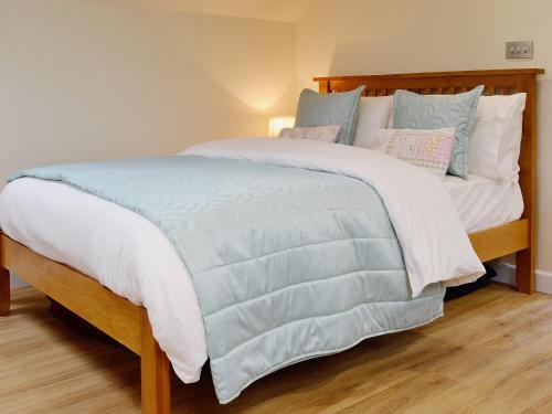 a bed with a blue and white comforter and pillows at Magpies Rest in Horrabridge