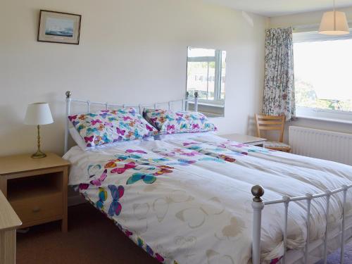 een slaapkamer met een bed met een bloemrijk dekbed bij Far Horizons in Seaview