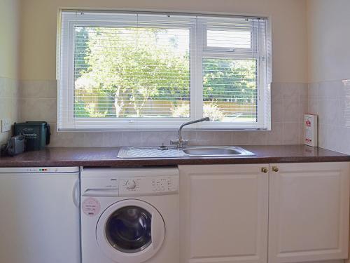 a kitchen with a sink and a washing machine at Far Horizons in Seaview