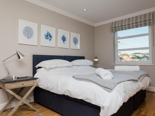 a bedroom with a large bed with a desk and a window at 16 Marinus in Cowes