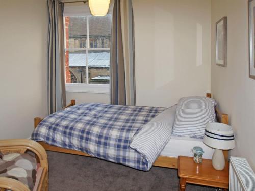 a small bedroom with a bed with a window at Dawns Gem in Whitby