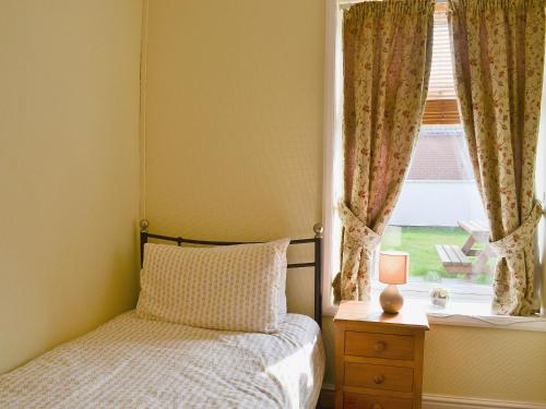 a bedroom with a bed and a window at Little Tern in Winterton-on-Sea