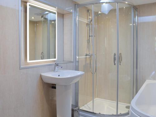 a bathroom with a glass shower and a sink at Booth Farm Bungalow in Hollinsclough