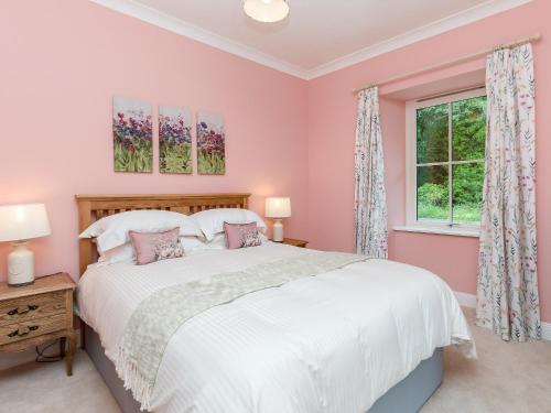 Un dormitorio con una gran cama blanca y una ventana en Graces Cottage en Port of Menteith