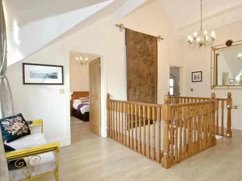 a living room with a crib and a bedroom at Magnolia Cottage in Aberaeron