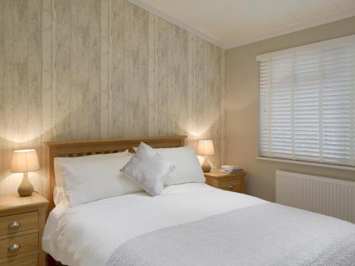 CortonにあるSeacliffのベッドルーム1室(白いベッド1台、ランプ2つ、窓付)