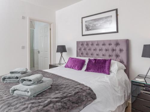 a bedroom with a large bed with purple pillows at 3 Waterwheel Apartment in Charlestown