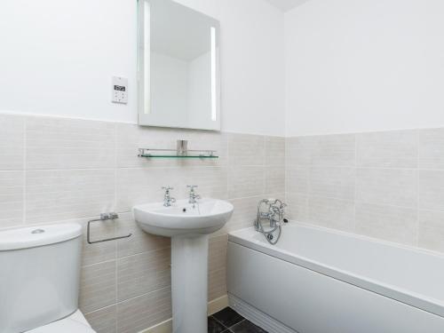 3 Waterwheel Apartment في تشارلزتاون: حمام مع حوض ومرحاض وحوض استحمام