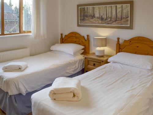 a bedroom with two beds with towels on them at Beech Barn in Horning