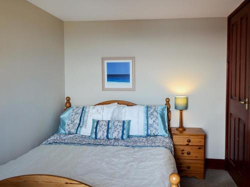 een slaapkamer met een bed met blauwe en witte kussens bij High Tide in Cellardyke