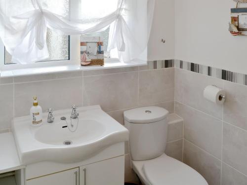 a bathroom with a white toilet and a sink at Tracara in Horning