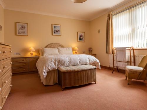 1 dormitorio con 1 cama y 1 silla en Staffin en Newcastleton