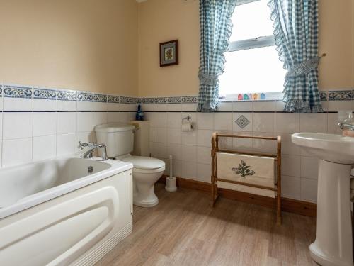 a bathroom with a tub and a toilet and a sink at Staffin in Newcastleton