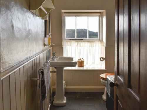 La salle de bains est pourvue d'un lavabo et d'une fenêtre. dans l'établissement Letterbox Cottage, à Far Sawrey