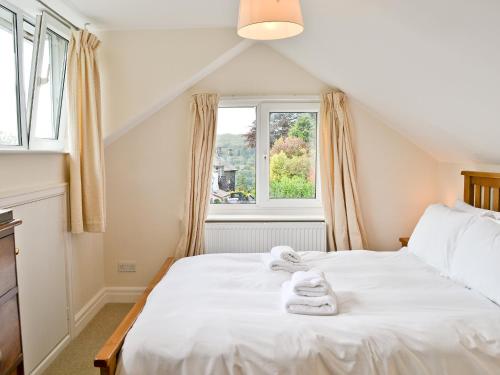 Un dormitorio con una cama blanca con toallas. en Kilnshaw, en Ambleside