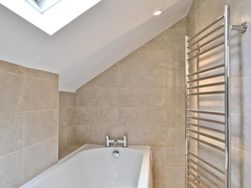een badkamer met een bad en een dakraam bij Kilnshaw in Ambleside