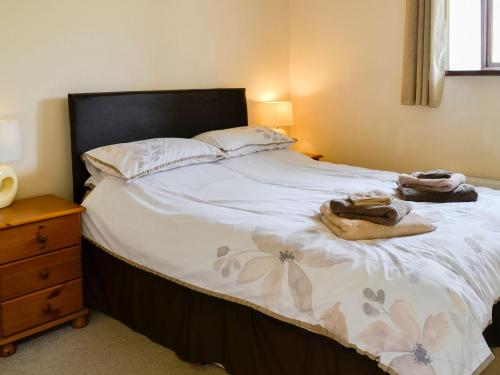 a bedroom with a bed with two towels on it at Mill Barn in Burnsall