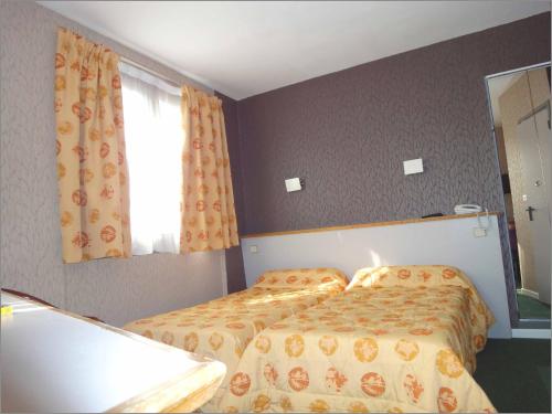 a bedroom with two beds and a window at Picardy Hôtel-Gare du Nord in Paris