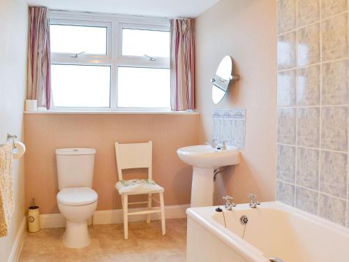 a bathroom with a toilet and a sink and a bath tub at Shingle Cottage in Seascale