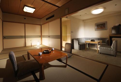 a living room with a table and chairs in a room at Suimeikan in Gero