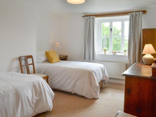 a bedroom with two beds and a window at Chaplands in Beaford