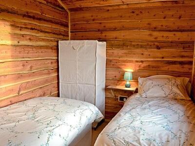 ein Schlafzimmer mit einem Bett in einem Blockhaus in der Unterkunft Moorside Lodge in Soutergate