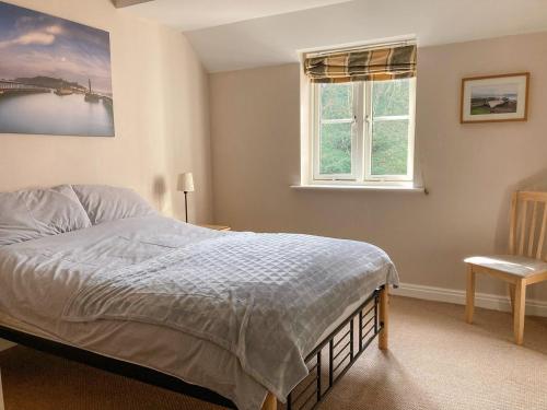 a bedroom with a bed and a window and a chair at River Side in Whitby