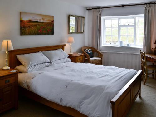 sypialnia z dużym łóżkiem i oknem w obiekcie East House Farm w mieście Beckermonds