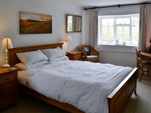 ein Schlafzimmer mit einem großen Bett und einem Fenster in der Unterkunft East House Farm in Beckermonds