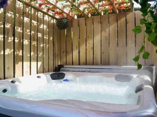 a white bath tub sitting next to a wooden fence at Dyffryn Haidd in Llanafan