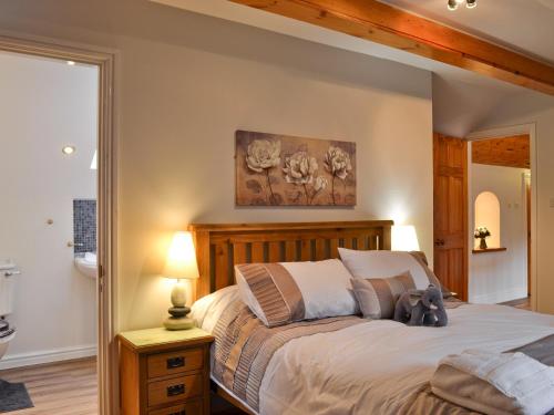 a bedroom with a bed with a wooden headboard at Dyffryn Haidd in Llanafan