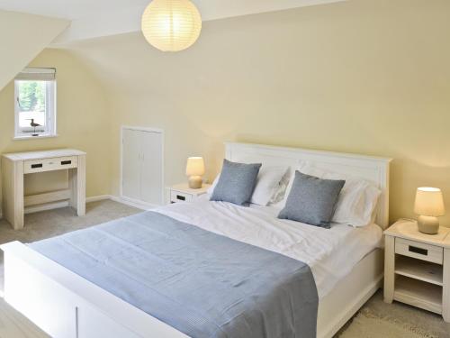 a bedroom with a large white bed with two night stands at Watersmeet in Looe