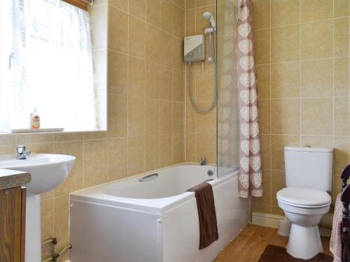 a bathroom with a tub and a toilet and a sink at Abbotts Ball Farm in Potterne