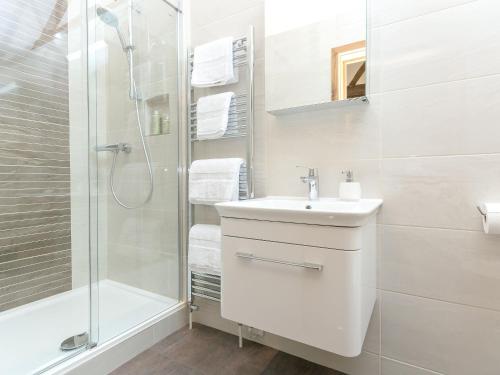 a white bathroom with a sink and a shower at The Old Dairy-ukc2112 in Royal Wootton Bassett