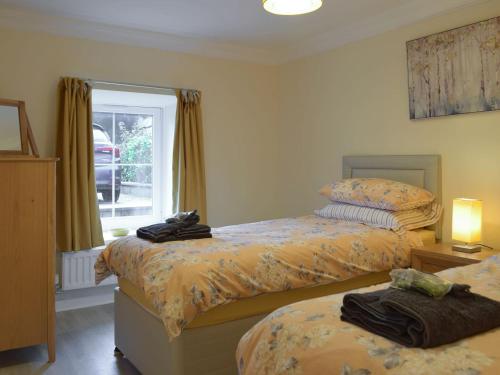 1 dormitorio con 2 camas y ventana en Victoria House - Uk13380, en Llanstephan