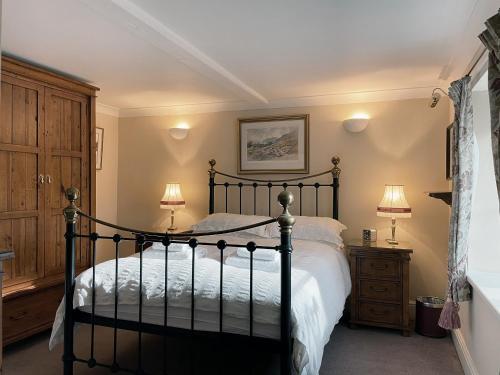 ein Schlafzimmer mit einem schwarzen Bett und zwei Lampen in der Unterkunft Bunbury Cottage in Keswick