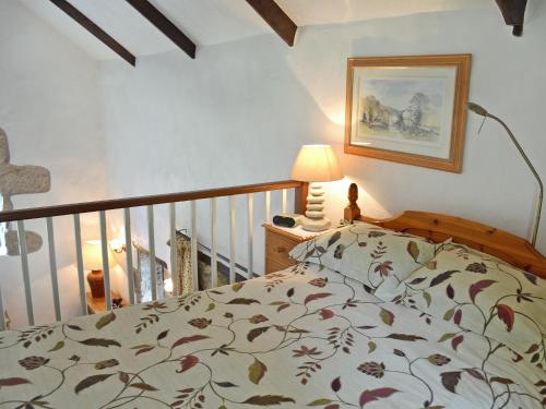 a bedroom with a bed and a lamp and a staircase at Chywood Barn in Carleen