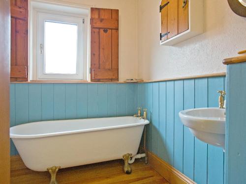 ein Badezimmer mit einer weißen Badewanne und einem Waschbecken in der Unterkunft The Boot in Dulverton